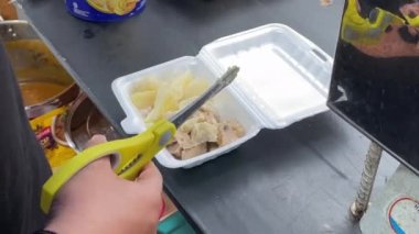 20 Kasım 2023, Güney Kalimantan, Endonezya. Satıcı alıcılar için hamur işi ya da siomay hazırlıyor. Siomay, patates, yumurta ve lahana dilimli balık köftesi..