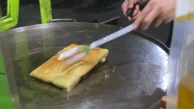 Genellikle martabak olarak adlandırılan Endonezya 'dan ünlü yiyecekler yapma süreci. Martabak, Endonezyalılar arasında sıklıkla salatalık turşusuyla servis edilen popüler bir paket yiyecek. Yumurta, et ve baharatla doldurulmuş tuzlu tavada kızartılmış börek..