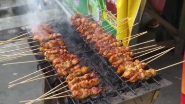 Sıcak kömürde ızgara tavuk şişi. Tavuk satay ya da sate Endonezya 'nın geleneksel yemeklerinden biridir ve genellikle fıstık içeren baharatlı bir sosla servis edilir..