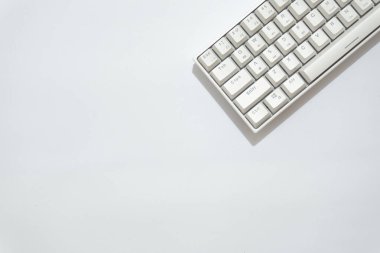 Beyaz mekanik klavyenin üst görünümü, beyaz arkaplanda izole edilmiş çeşitli düzenlere sahip beyaz klavye.