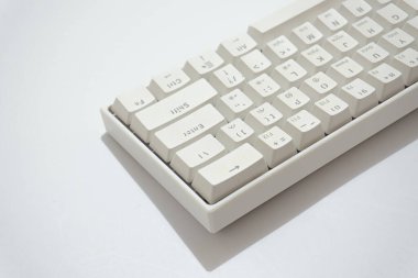 Beyaz mekanik klavyenin üst görünümü, beyaz arkaplanda izole edilmiş çeşitli düzenlere sahip beyaz klavye.