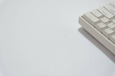 Beyaz mekanik klavyenin üst görünümü, beyaz arkaplanda izole edilmiş çeşitli düzenlere sahip beyaz klavye.