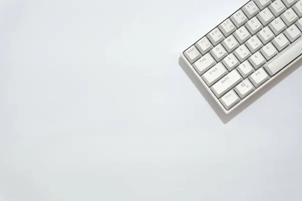 Beyaz mekanik klavyenin üst görünümü, beyaz arkaplanda izole edilmiş çeşitli düzenlere sahip beyaz klavye.