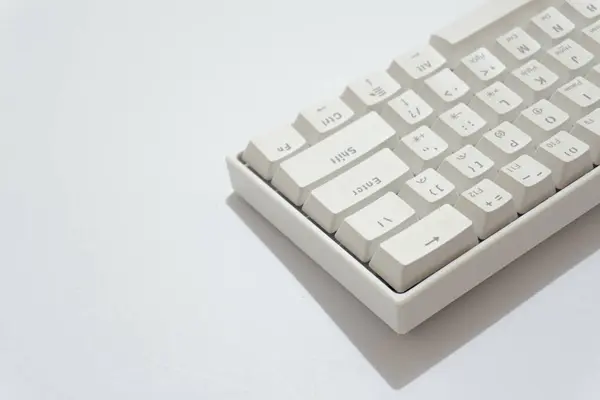 Beyaz mekanik klavyenin üst görünümü, beyaz arkaplanda izole edilmiş çeşitli düzenlere sahip beyaz klavye.