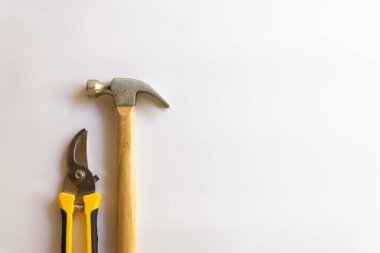 Ahşap saplı metal çekiç ve budama makası ya da beyaz arkaplanda izole edilmiş çeşitli desenli bahçe düzenleyicisi..