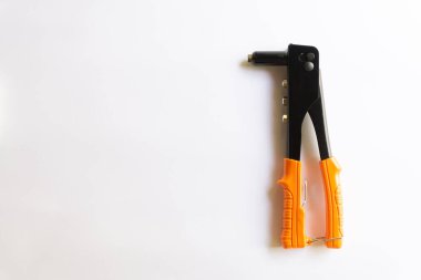 Turuncu saplı perçin aleti ve beyaz arka planda izole edilmiş çeşitli el perçinleri için gümüş kör perçin..