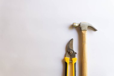 Ahşap saplı metal çekiç ve budama makası ya da beyaz arkaplanda izole edilmiş çeşitli desenli bahçe düzenleyicisi..