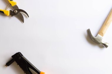 Ahşap saplı metal çekiç, perçin aracı ve budama makası ya da beyaz arka planda çeşitli yerleşimlere sahip bahçe düzenleyicisi.