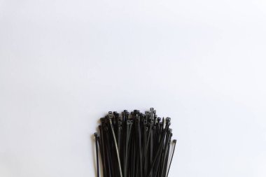 Black plastic cable ties with various layouts isolated on white background. clipart