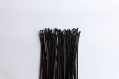 Beyaz arkaplanda izole edilmiş çeşitli yerleşimlere sahip siyah plastik kablo bağlantıları.