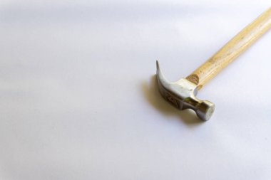 Metal çekiç ve ahşap saplı, beyaz arka planda çeşitli desenler var..