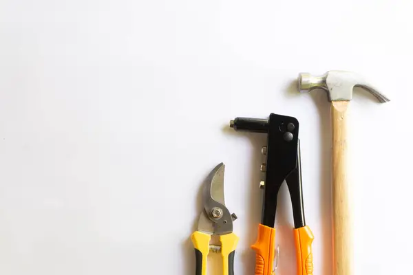 Ahşap saplı metal çekiç, perçin aracı ve budama makası ya da beyaz arka planda çeşitli yerleşimlere sahip bahçe düzenleyicisi.