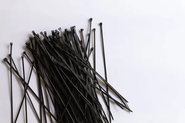 Beyaz arkaplanda izole edilmiş çeşitli yerleşimlere sahip siyah plastik kablo bağlantıları.