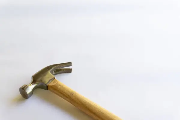 Metal çekiç ve ahşap saplı, beyaz arka planda çeşitli desenler var..