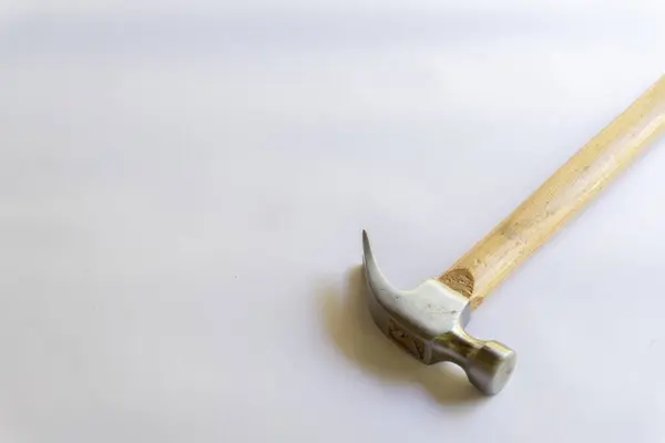 Metal çekiç ve ahşap saplı, beyaz arka planda çeşitli desenler var..