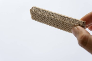 Beyaz arka planda izole edilmiş çikolatalı gofret tutan bir adam..