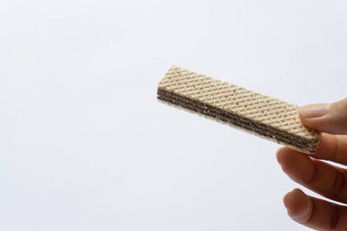 Beyaz arka planda izole edilmiş çikolatalı gofret tutan bir adam..