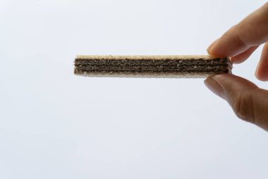 Beyaz arka planda izole edilmiş çikolatalı gofret tutan bir adam..