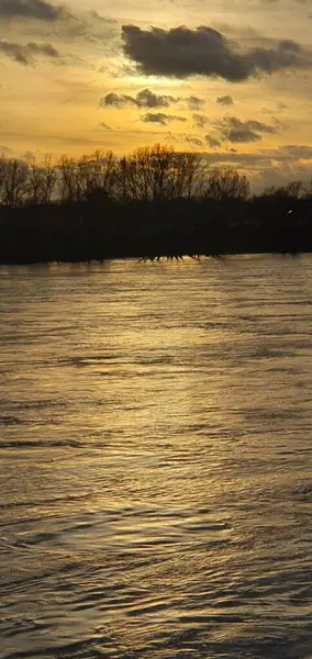 River at high water during a sunset in winter without snow