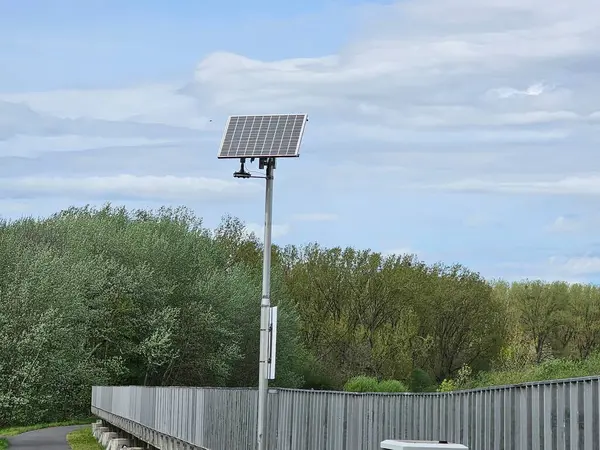 Solarpanel am Zaun einer Landbruecke auf einem Pfahl
