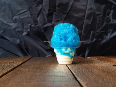 Mavi Hawaii traşlı buzlu dondurma, buzlu dondurma ya da vanilyalı dondurma. Kırsal arka planda, çiçek şeklinde bir koni..