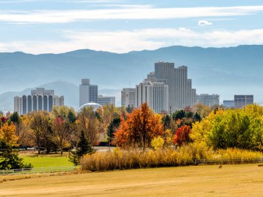 Reno, Nevada ABD - 30 Ekim 2021: Sonbaharda Reno şehri önü parlak renkli ağaçlarla ve arkası sisli dağlarla çevrili.