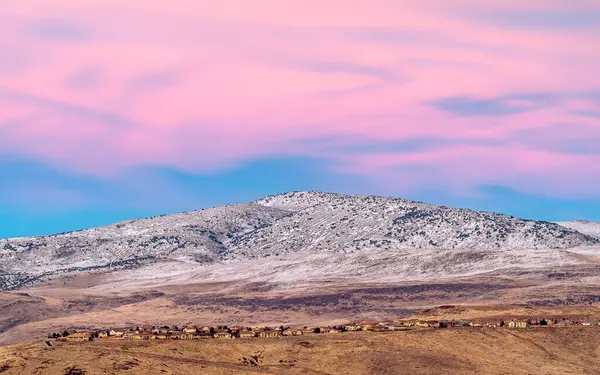Reno Sparks Nevada bölgesindeki dağ sırtı çizgilerinin üzerindeki mor gökyüzü ile gün batımında karla kaplı..