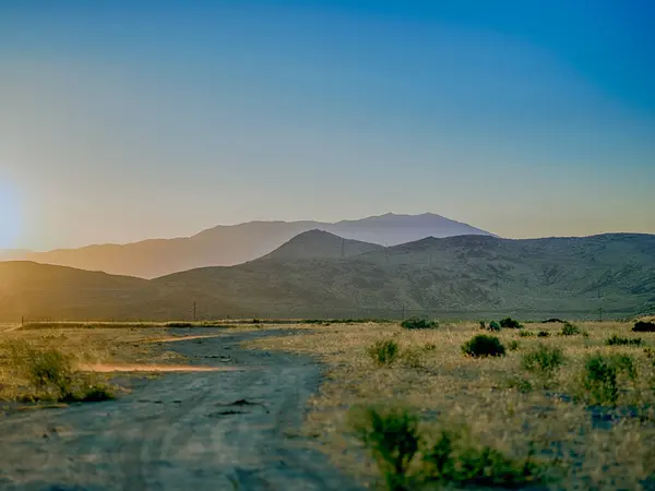 Dusty dirt country road  with a diminishing perspective in Northern Nevada near Reno during summer.