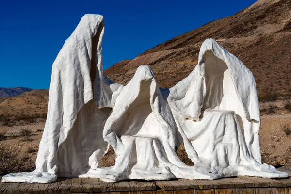 Rhyolite, Nevada ABD - 19 Ekim 2021: Rhyolite çölündeki hayalet heykelleri. Rhyolite eski bir maden kasabası ve şimdi Ölüm Vadisi Milli Parkı 'nın hemen dışında bir hayalet kasaba..