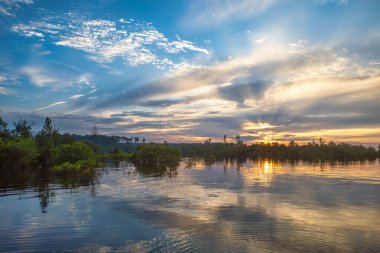 Sam Rayburn Gölü 'ndeki dramatik günbatımı yaz boyunca Teksas' ın güneydoğusunda yer almaktadır. Suda güzel yansımalar ve yukarıda dramatik bulutlar ve gökyüzünde güneş ışınları vardır..