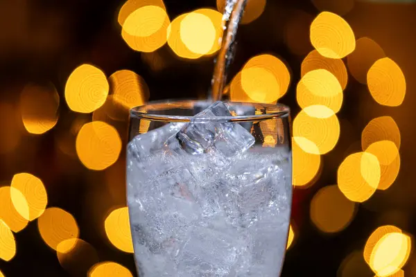 Noel arkaplanı olan bir bardağa temiz bir içecek dolduruyorum..