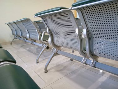 Metalik sırt desteği ve temiz odada yeşil yastıklı modern kapalı oturma düzeneği