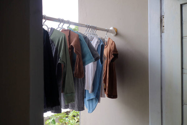 T shirts hanging on hangers inside house