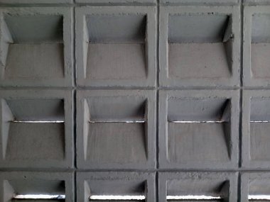 Geometrik kare girintili beton duvar ve küçük havalandırma boşlukları