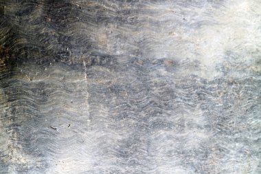 Dalgalı yüzey desenini gösteren yaşlı taşın yakın görüntüsü
