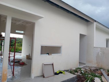 Beyaz duvarları ve açık alanları olan kısmen inşa edilmiş modern bir ev..