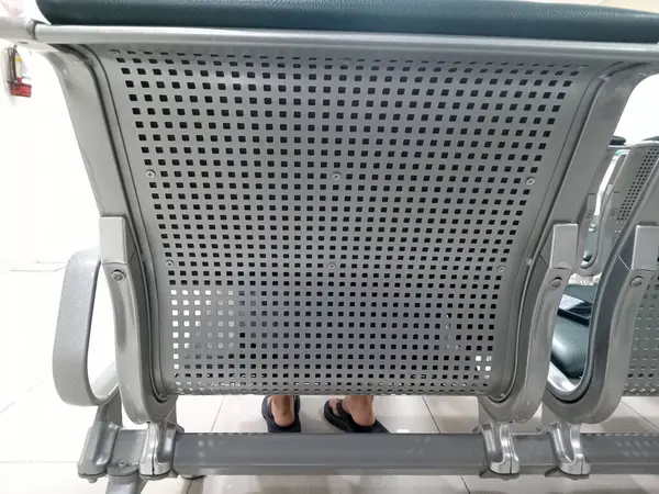 Delinmiş tasarımı olan metal bir havaalanı sandalyesinin arka planı.