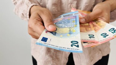 Avro parası elinde tutan kadın. 20 avroluk banknotlar vermek ve elinde farklı banknotlar tutmak, avro banknotları, Avrupa Birliği kağıt paraları. Maliye, işletme, yatırım, enflasyon, satın alma gücü ve sosyal kriz.
