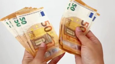Başlık: 50 avroluk banknotları sayan bir elin yakın çekimi. Euro banknotları, Avrupa Birliği kağıt para birimi. Para biriktirme kavramı.
