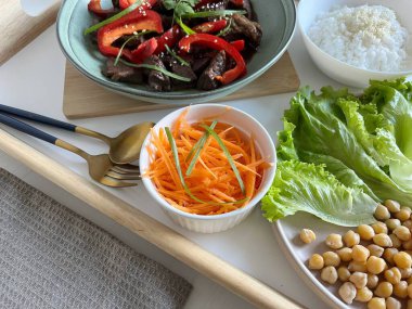 Asya yemekleri: Masada sebze ve pirinç çeşitleri. Kırmızı biberli ve susamlı Teriyaki bifteği.