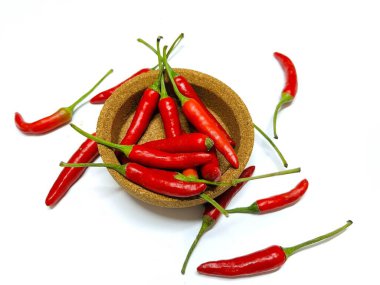 Red chilies are served on a wooden plate. Isolated on white background with copy space. Clipping path. Perfect for design element, spicy food concept or any commercial usages clipart