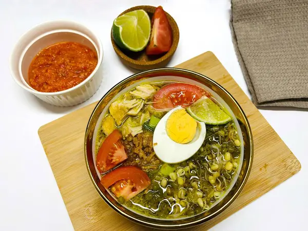 stock image Chicken Soto or Soto Ayam in Indonesia. Soto ayam is a traditional Indonesian dish which uses ingredients such as chicken, vermicelli, bean sprout with turmeric as main ingredient add in the broth.