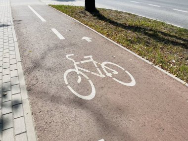 Parktaki asfalt yolda bisiklet tabelası. Bisiklet yolu