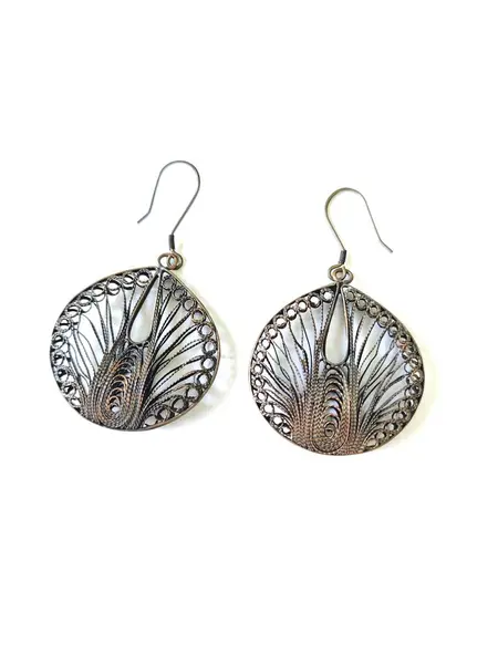 El yapımı bakır küpeler beyaz arkaplanda izole edilmiş.