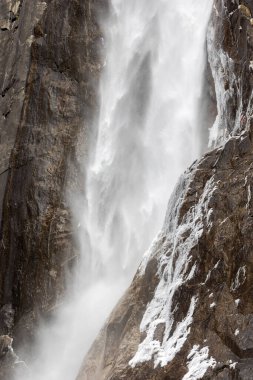 Yosemite 'nin aşağısındaki şelaleye yaklaşırken ön planda kar var.