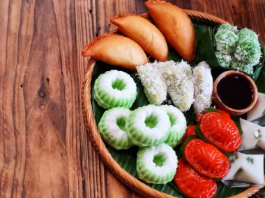 'Kue basah' olarak da bilinen renkli geleneksel Endonezya kekleri, muz yapraklı bir katman ile örülmüş bambu tavada sergilenmektedir. Mutfak alanları, kültür festivalleri ve seyahat blogları için ideal.