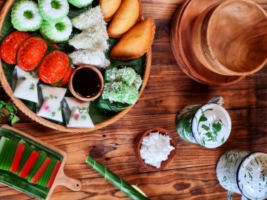 'Kue basah' olarak da bilinen renkli geleneksel Endonezya kekleri, muz yapraklı bir katman ile örülmüş bambu tavada sergilenmektedir. Mutfak alanları, kültür festivalleri ve seyahat blogları için ideal.