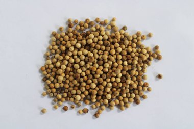 Beyaz bir yüzeyde biber tohumu yığını. Biber, baharatlı ve sıcak bir tadı olan yemek pişirme baharatlarından biridir..