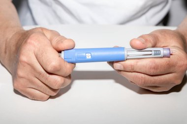 Ozempic insülin enjeksiyon kalemi veya şeker hastaları için insülin kartuş kalem. Şeker hastası için elinde enjeksiyon kalemi tutan bir adam. Diyabet hastaları için tıbbi ekipman. 