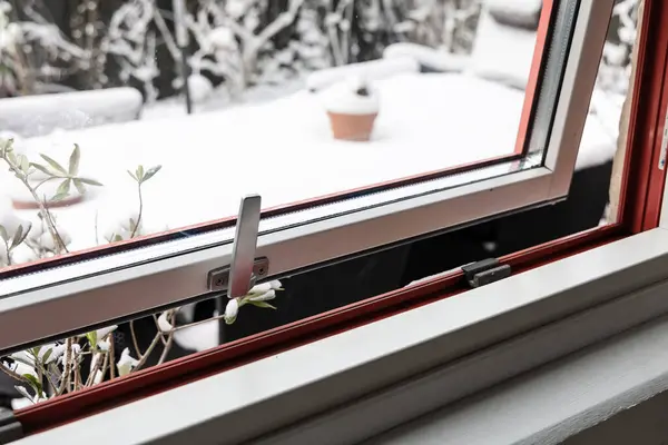 Open window on a winter day. Winter and snow outside the window in the garden. High quality photo